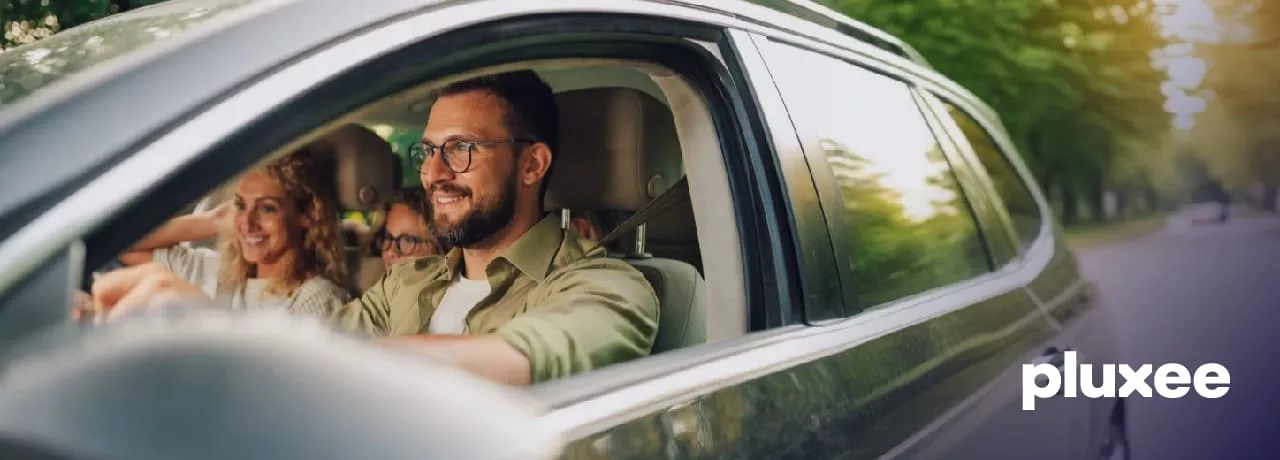 Pareja conduciendo con seguridad y aprovechando vales de gasolina.